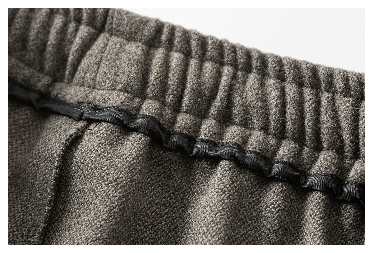 Close-up of a gathered gray-brown waistband with a black ribbon threaded through it.