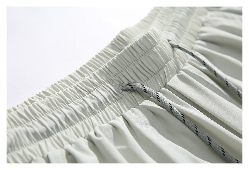 Close-up of light-colored shorts showing the gathered elastic waistband and patterned drawcord.