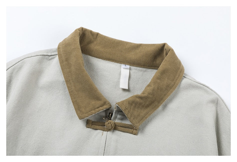 Close-up of the pale gray jacket's tan corduroy collar and knotted frog closure.