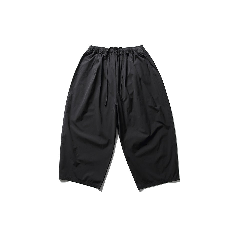 Black wide-leg cropped pants with elastic drawstring waist, flat lay front view