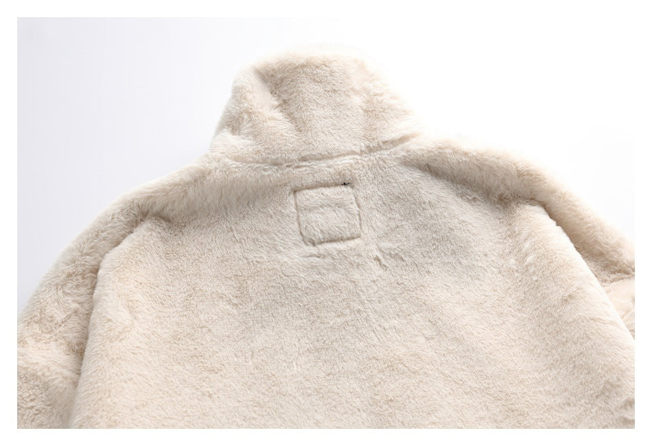 Close view of the cream plush coat's back and raised collar, laid flat.