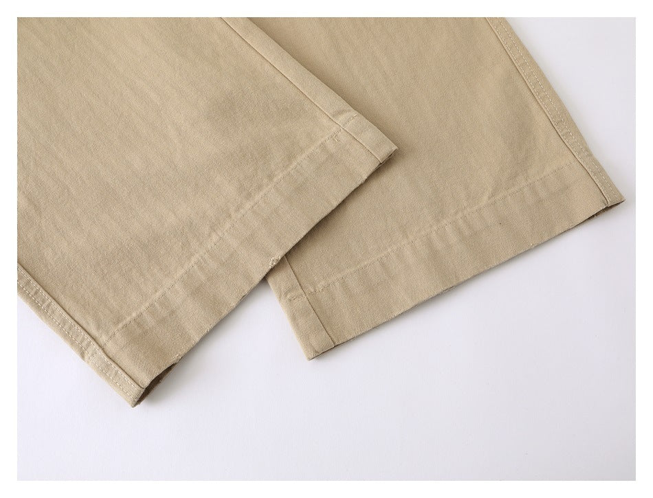 Close-up of beige garment hems with double-row stitching and folded seam edges.