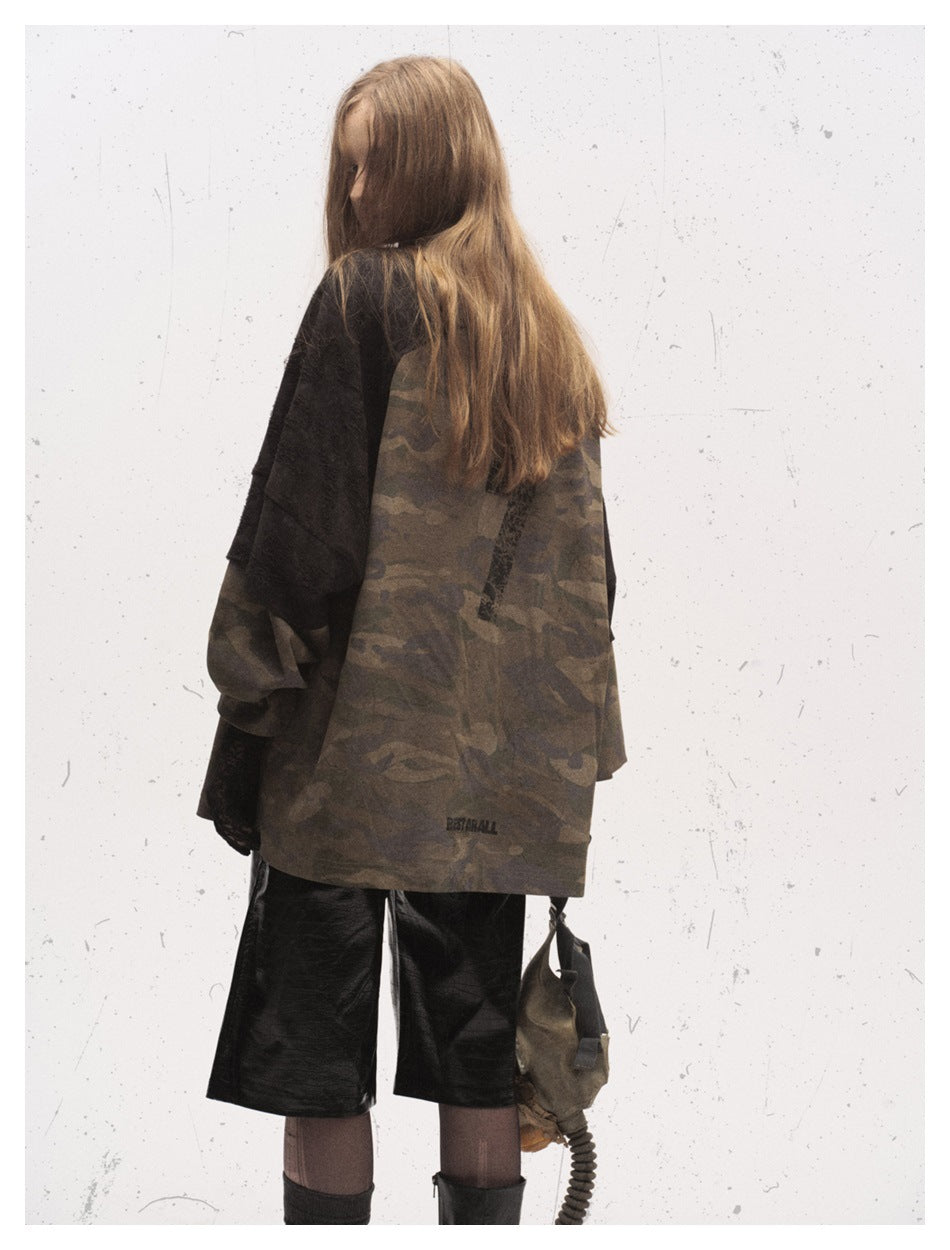Model wearing an oversized camouflage top with black short sleeves, shown from behind with black shorts.
