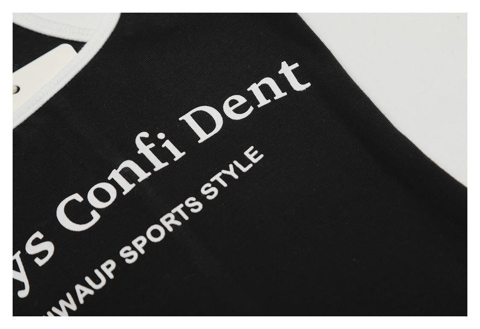 Close-up of white “Confident” and “SPORTS STYLE” lettering on black fabric near the white-trimmed edge.