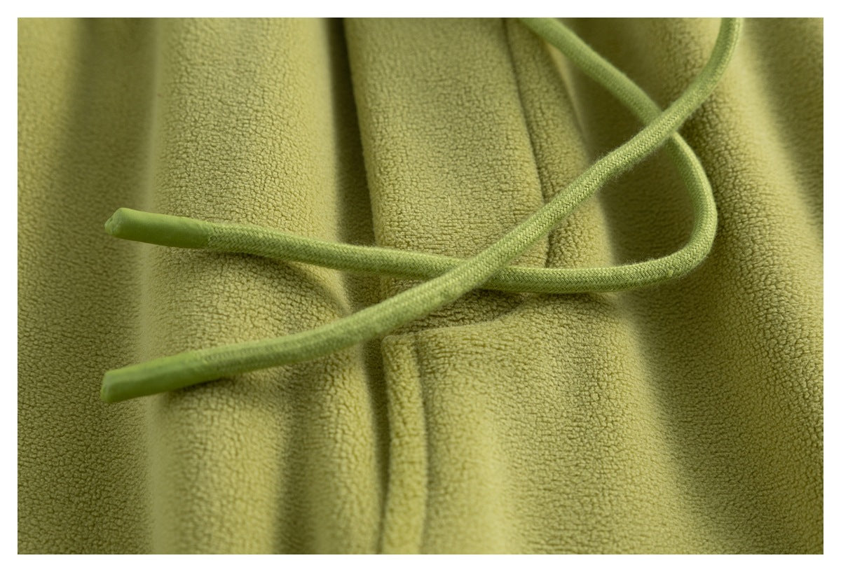 Close-up of the olive-green pants' matching drawstrings against the textured fabric.