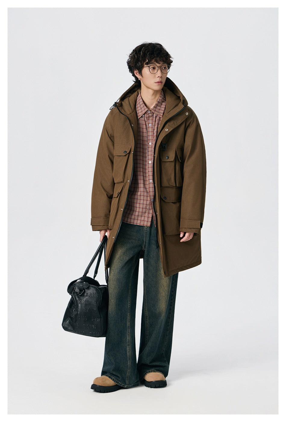 Full-length view of a model wearing a brown hooded parka with multiple flap pockets.