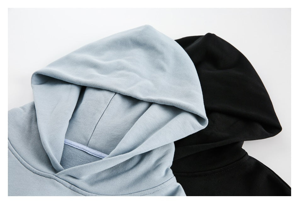 Close-up of the hoods and necklines of light blue and black sweatshirts.