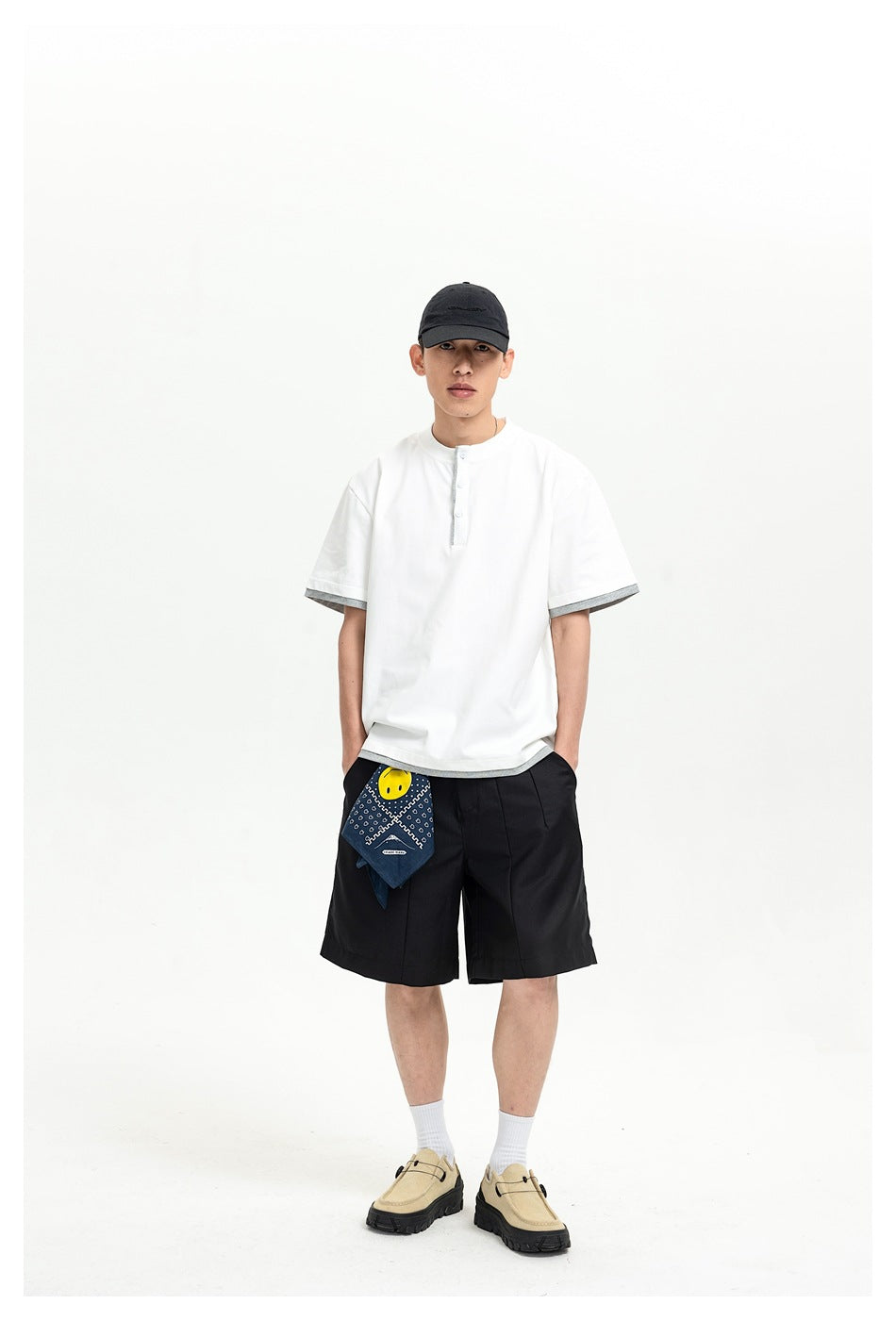 Front view of a model wearing a white short-sleeve shirt with gray trim and black shorts.
