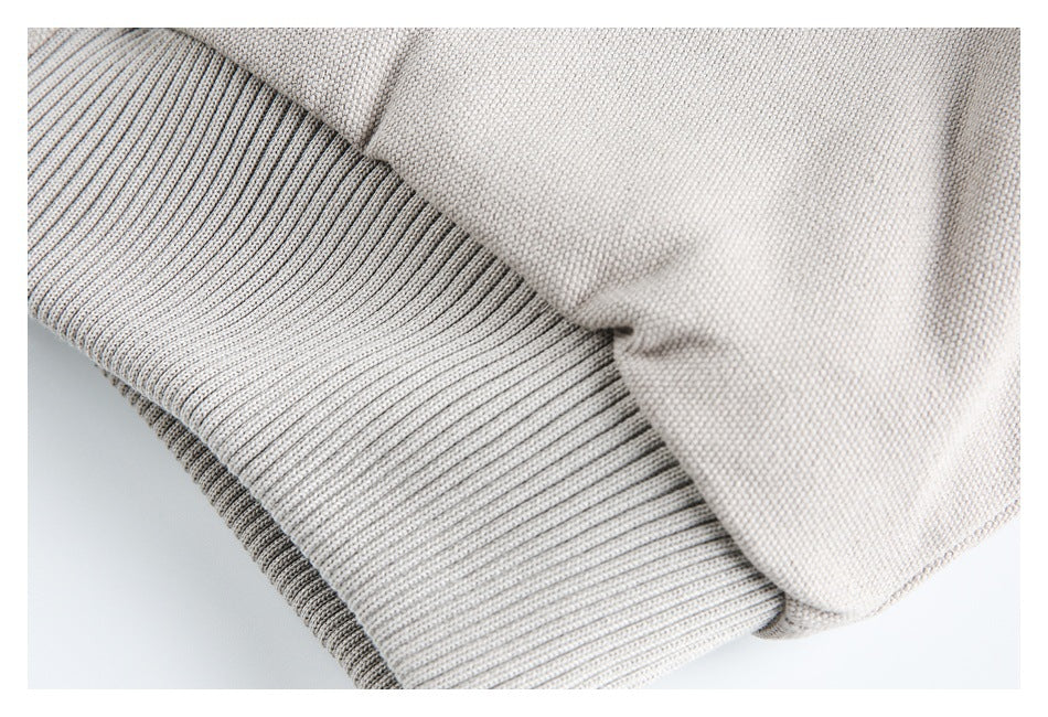 Close-up of a beige jacket's wide ribbed cuff and adjoining sleeve fabric.