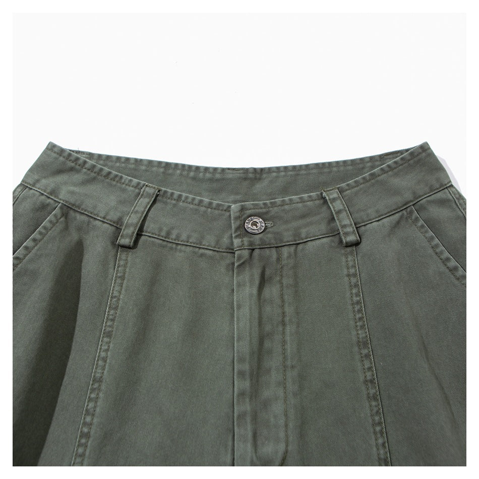 Close-up of the gray-green pants' waistband, button, belt loops, and front seams.
