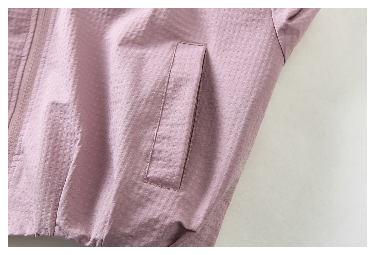Close-up of a dusty pink textured jacket with a vertical welt pocket and partial zipper.