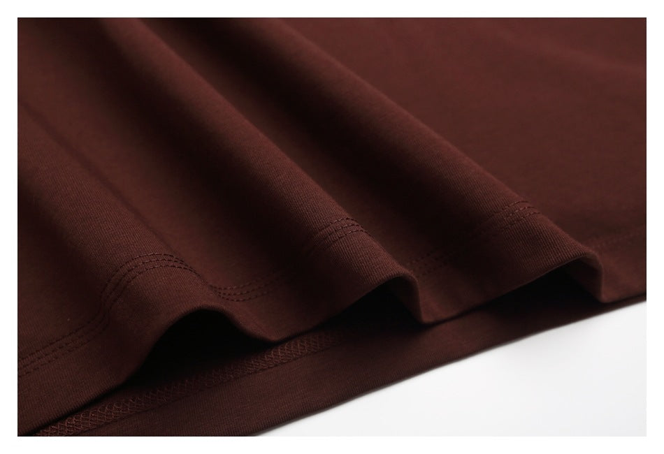 Close-up of the dark brown T-shirt's stitched lower hem and fabric folds.