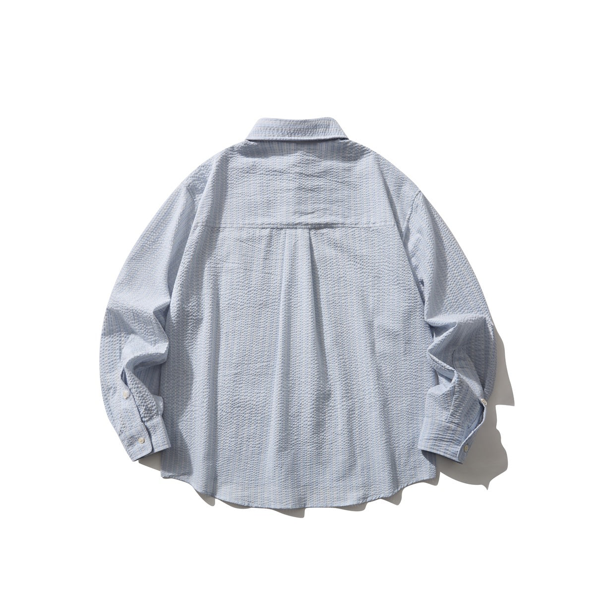 Back view of a light blue long-sleeve button-up shirt with a yoke and curved hem.