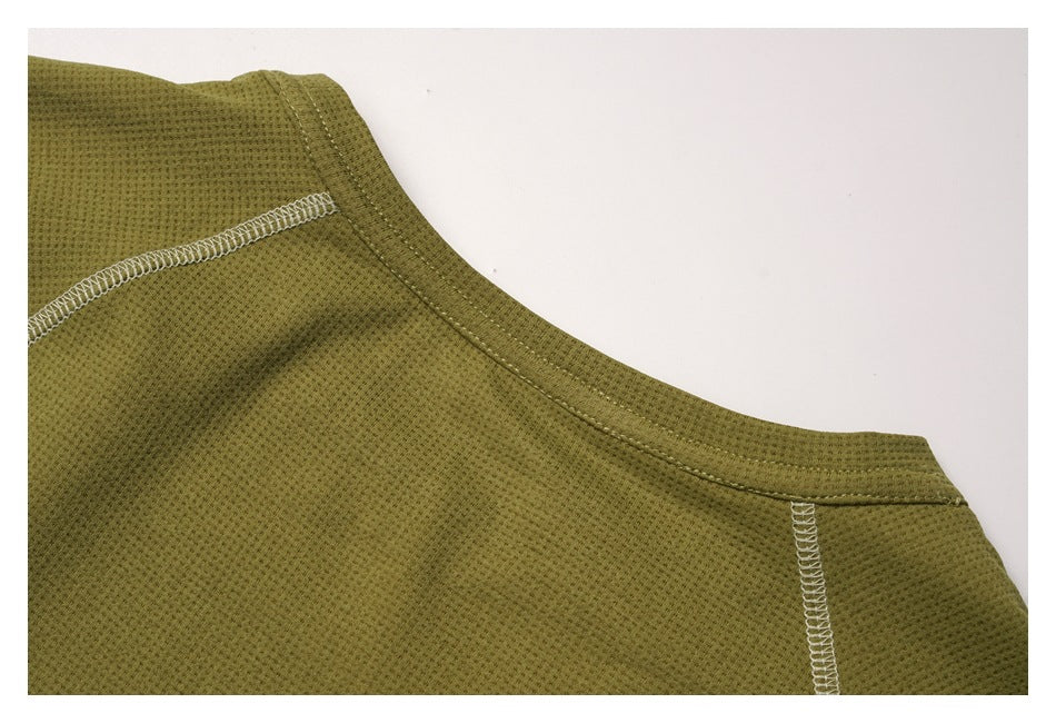 Close-up of an olive green garment neckline and shoulder seam with contrasting white overlock stitching.