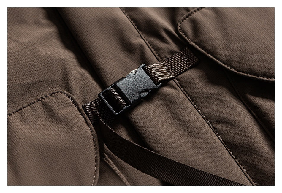 Close-up of a black plastic buckle and brown webbing strap on a brown garment.
