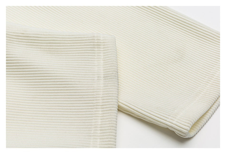 Close-up of an ivory sleeve cuff and the top's fine ribbed texture.