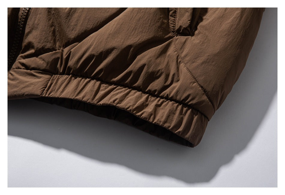 Close-up of the brown jacket's gathered lower hem and adjacent panel seams.
