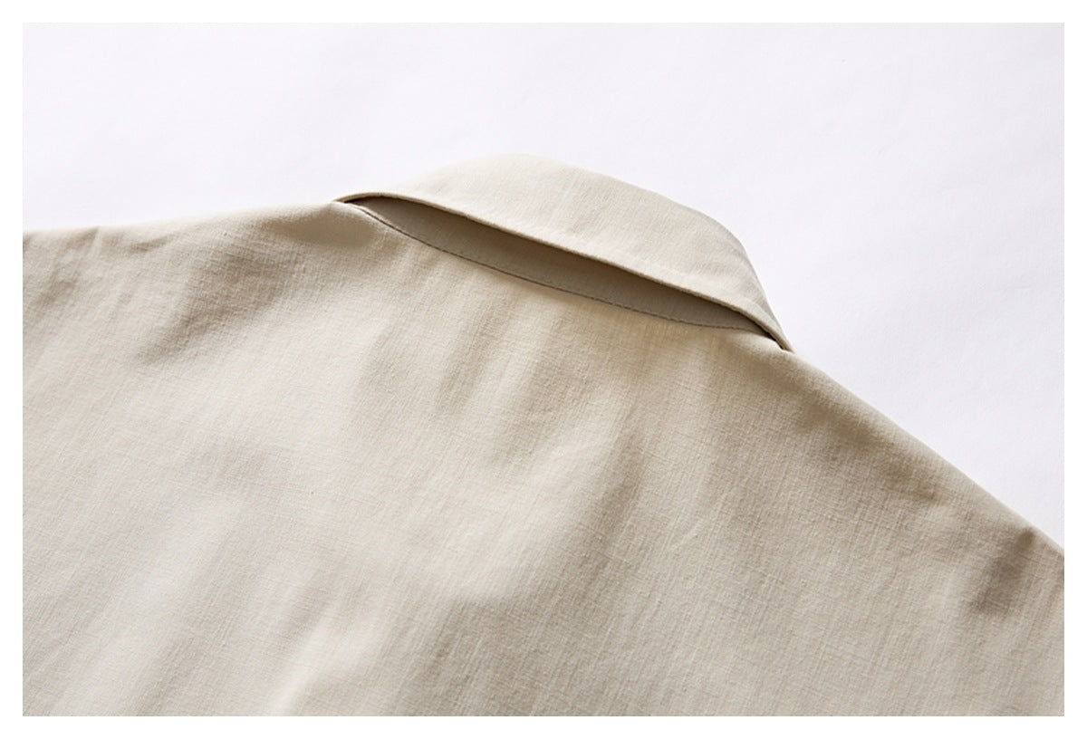 Close-up of the back collar and shoulder of an ivory shirt laid flat.
