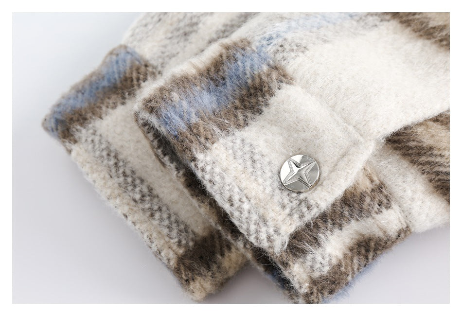 Close-up of a silver star-shaped button on a cuff of the cream, taupe, and pale blue plaid garment.