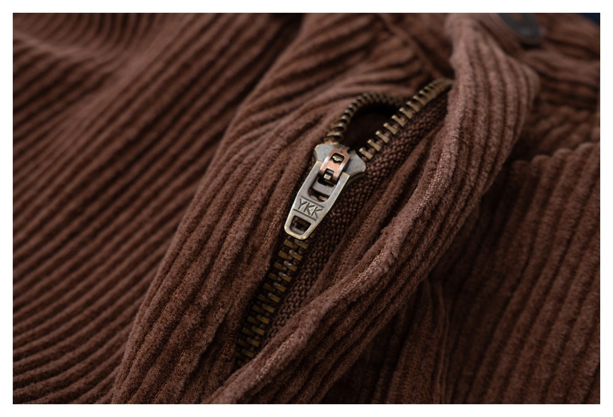 Close-up of the metal zipper and ribbed brown corduroy fabric on trousers.