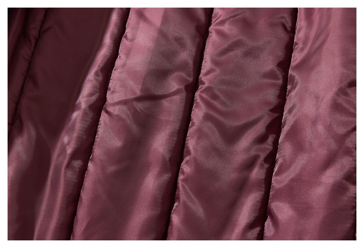 Close-up of shiny burgundy padded fabric with wide stitched channels.