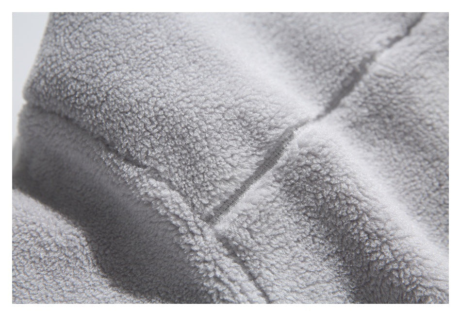 Macro view of light gray plush fleece folds and stitching.