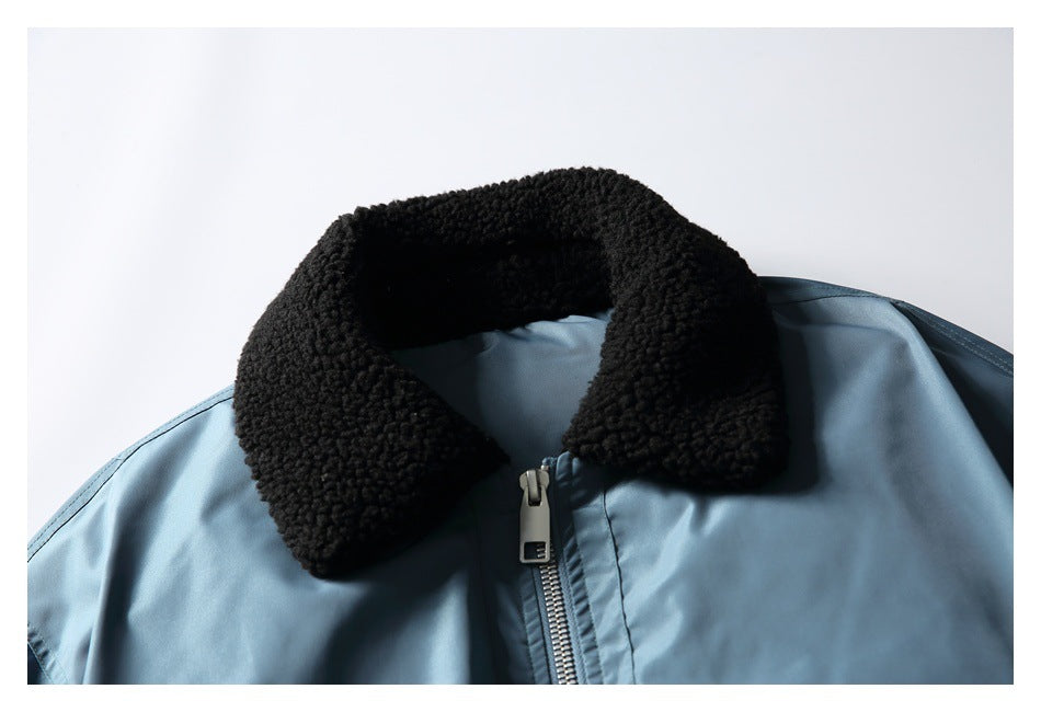 Close-up of the jacket's black fleece collar and silver front zipper against blue fabric.