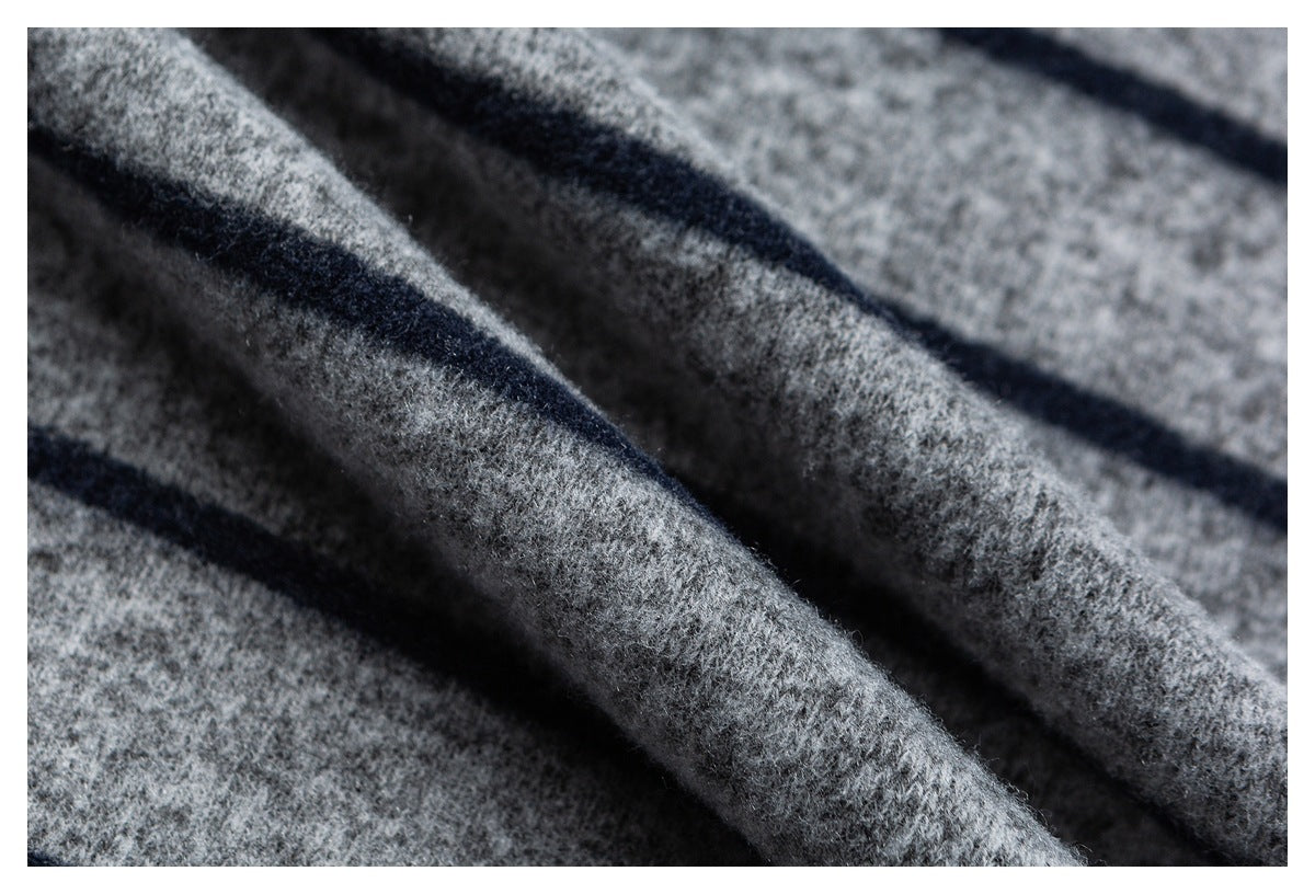 Macro view of the shirt's gray knit surface and dark horizontal stripes.