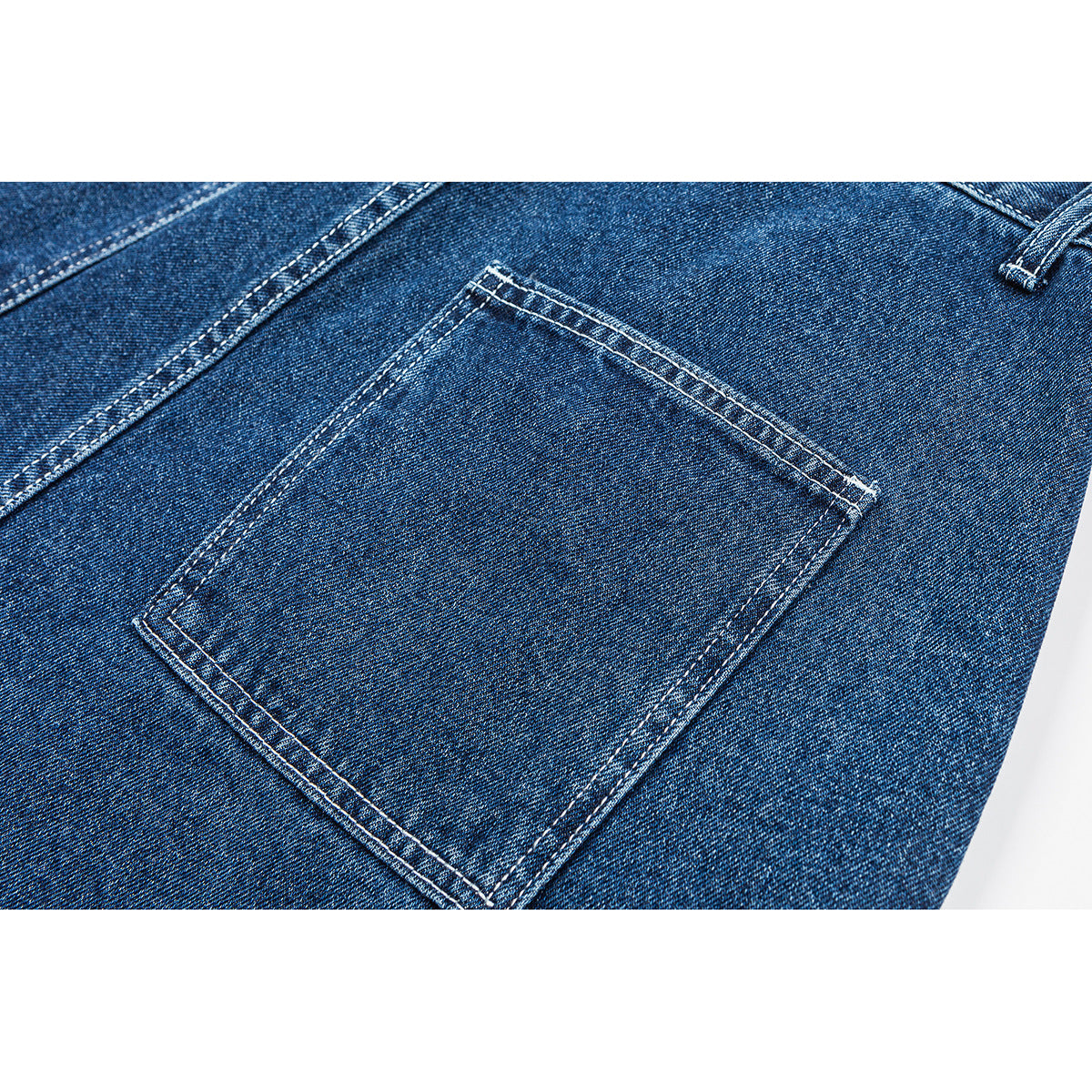 Close-up of blue denim shorts showing a rectangular back pocket with double-stitched edges.