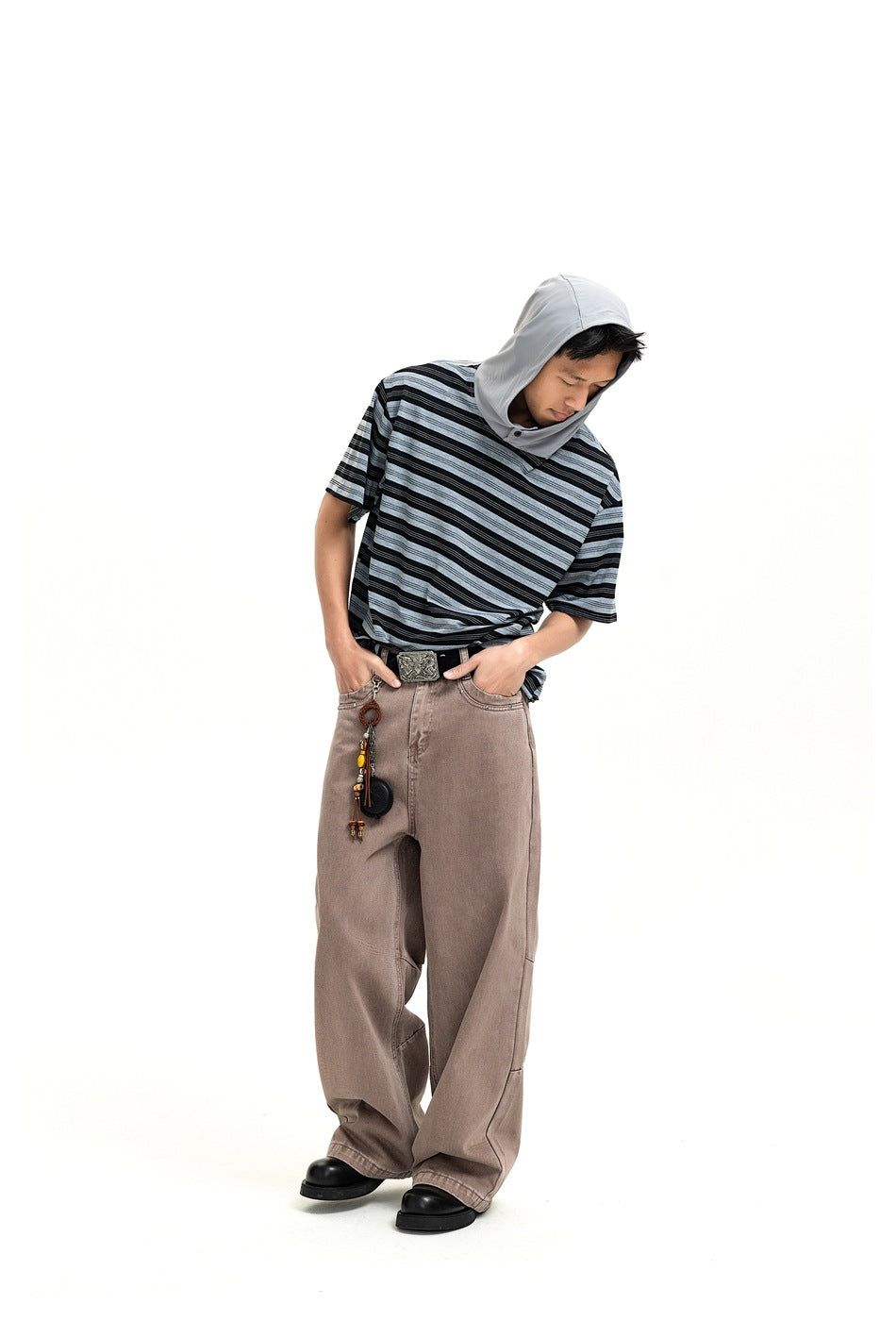 Full-length model wearing a black and gray striped short-sleeve hooded top with loose taupe pants.