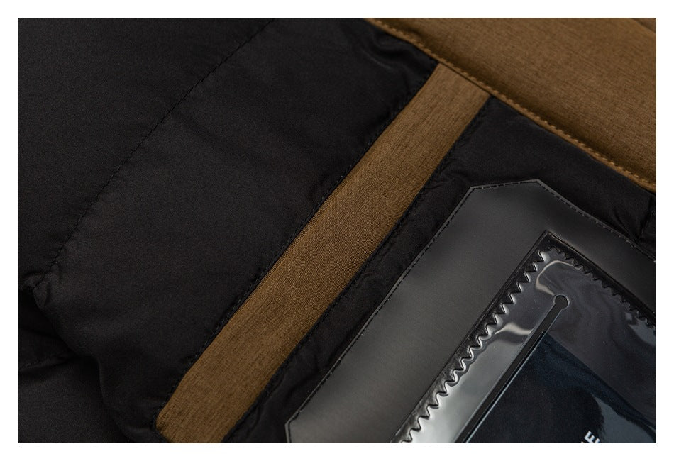 Close-up of a black padded garment with brown fabric trim and a glossy rectangular patch.