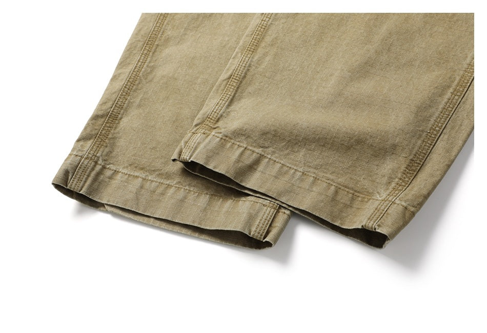 Close-up of the stitched hems on the tan pants legs.