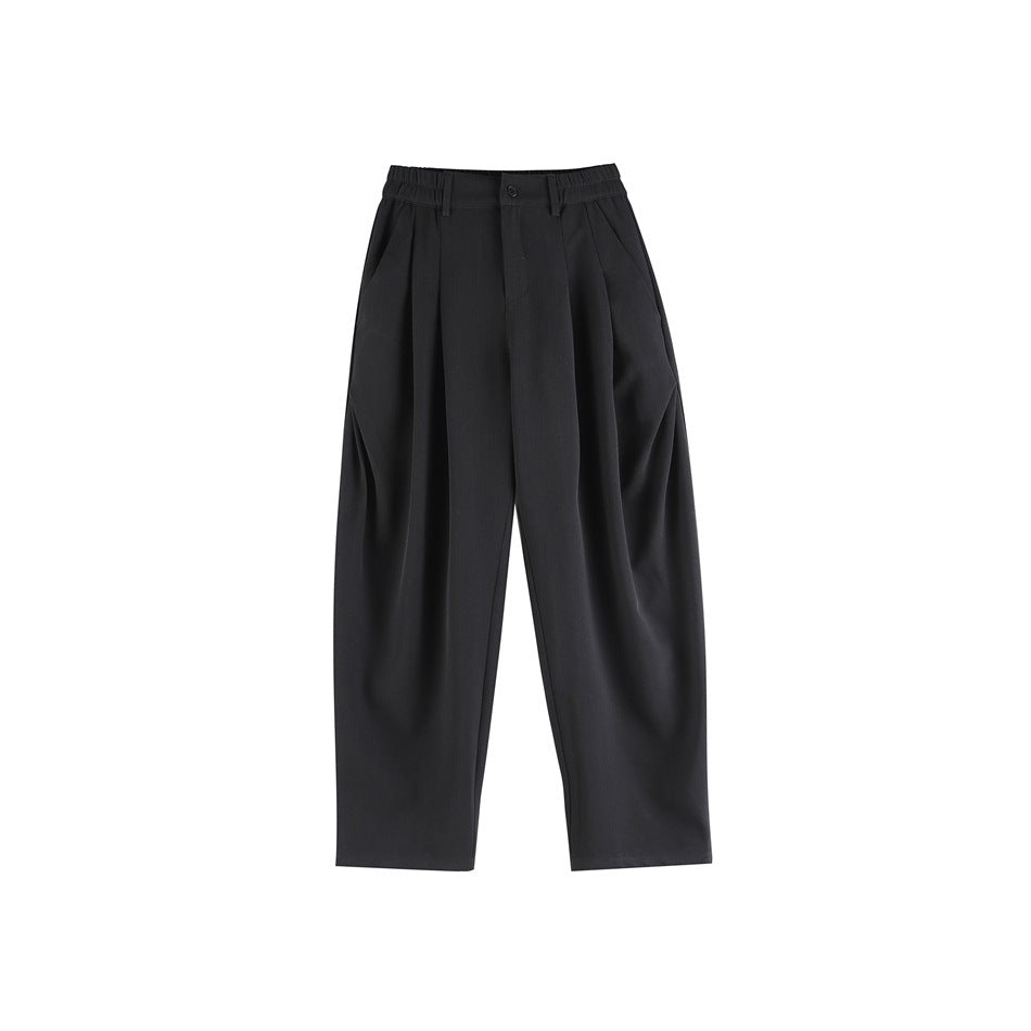 Black pleated wide-leg trousers with elastic waistband, button front and side pockets, flat lay front view