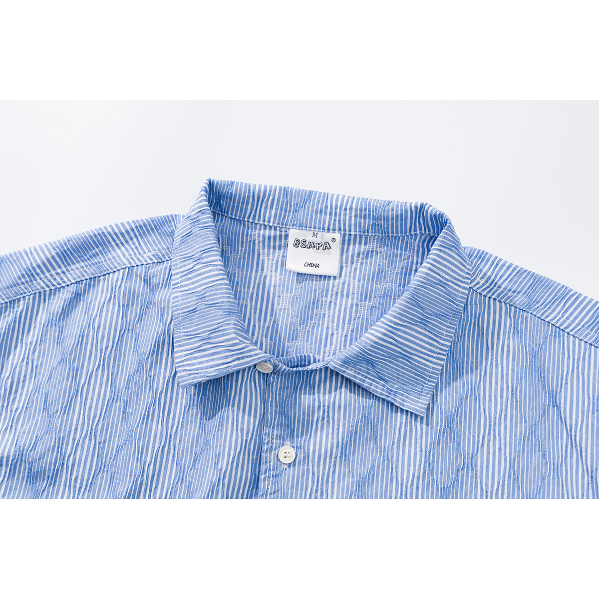 Close-up of a blue-and-white striped shirt collar, button placket, and neck label.