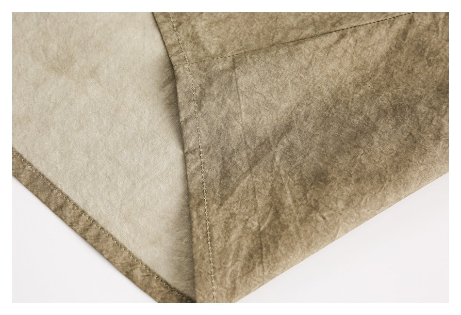 Close-up of taupe-brown garment seam with a lighter inner panel and stitched hem.