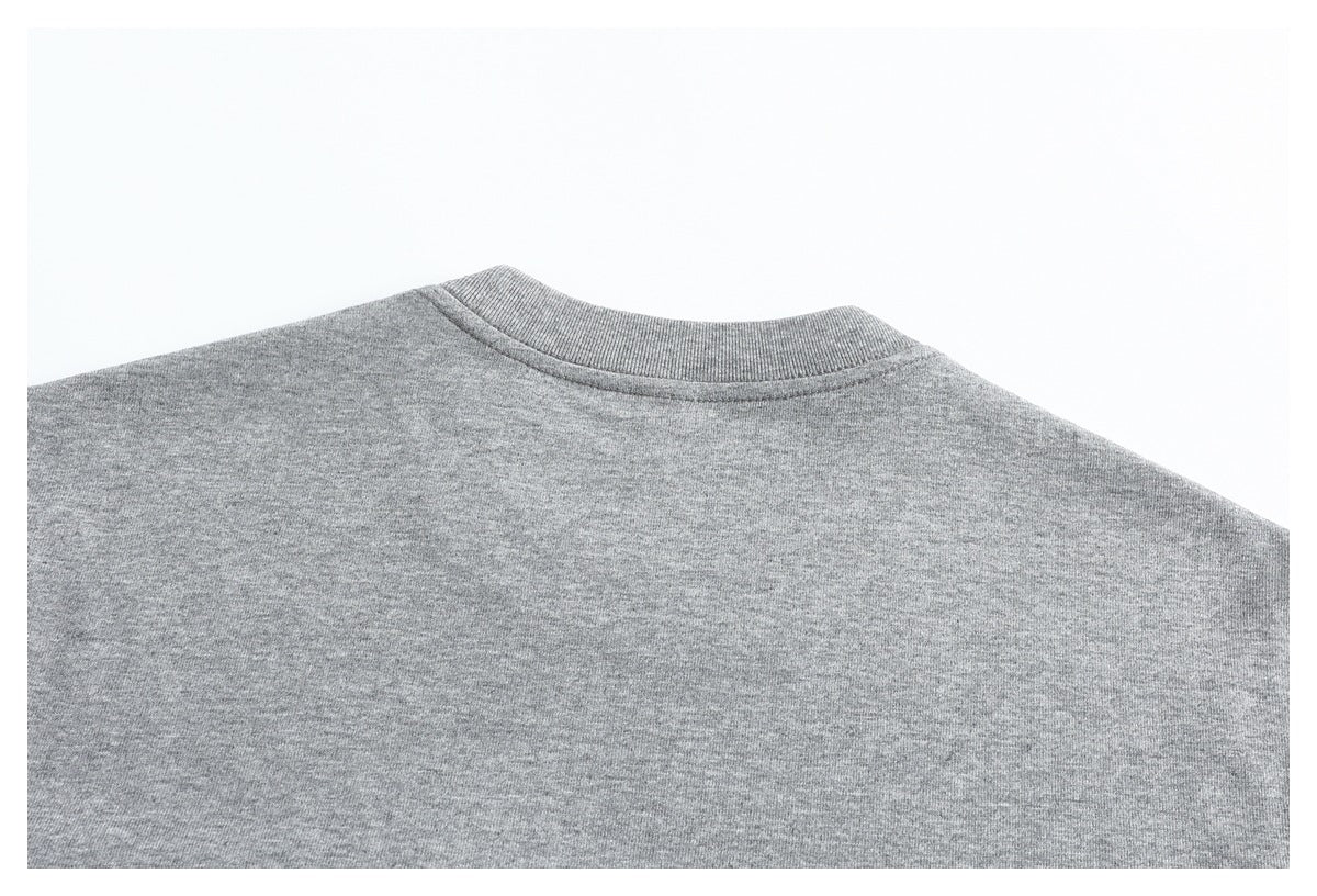 Close-up of the ribbed crew neckline and upper back of a heather gray garment.