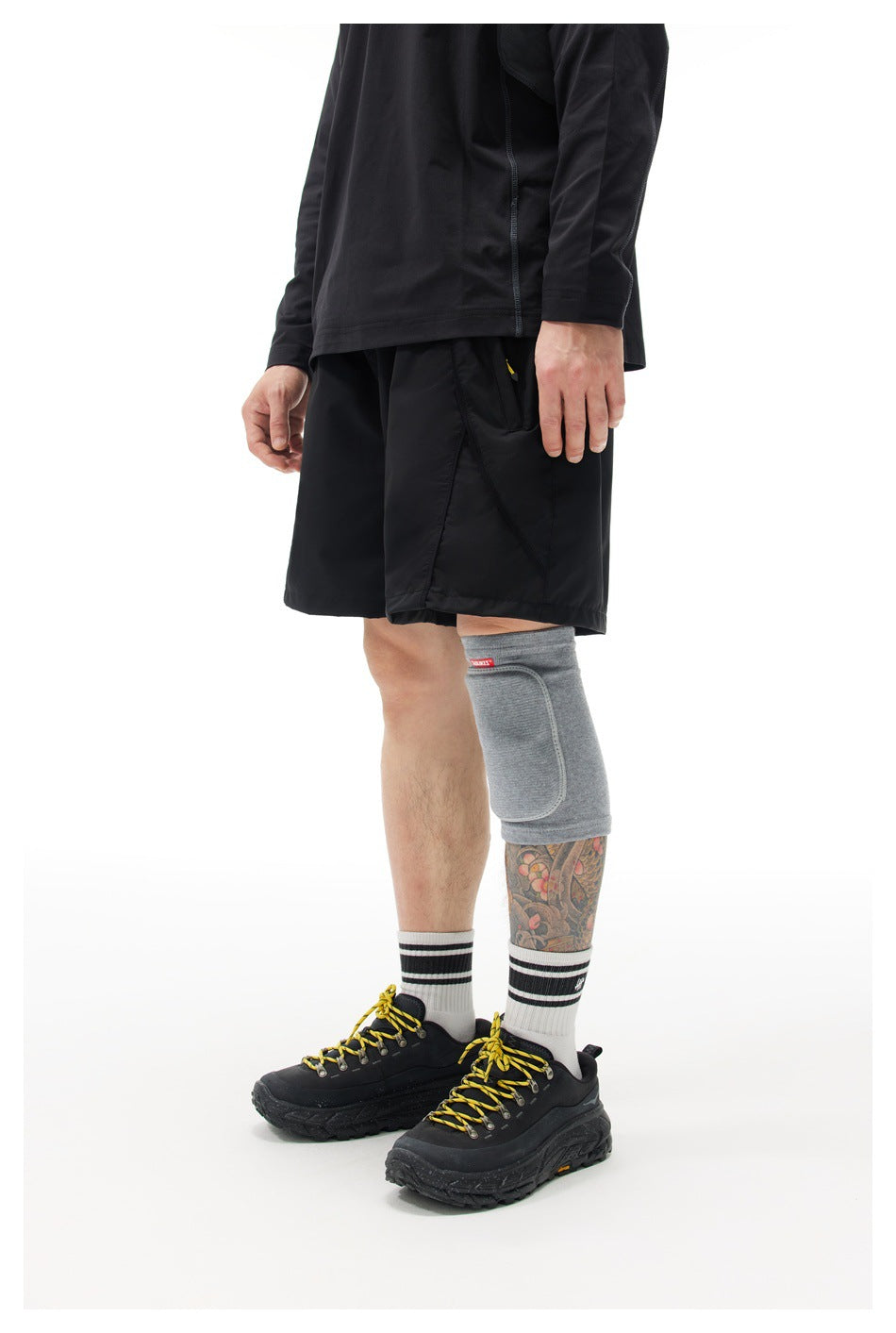 Angled side view of a model wearing black athletic shorts with a large side pocket.