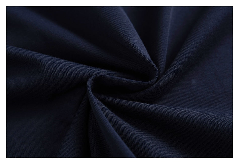 Close-up of dark navy fabric gathered into soft folds, showing its knit texture.