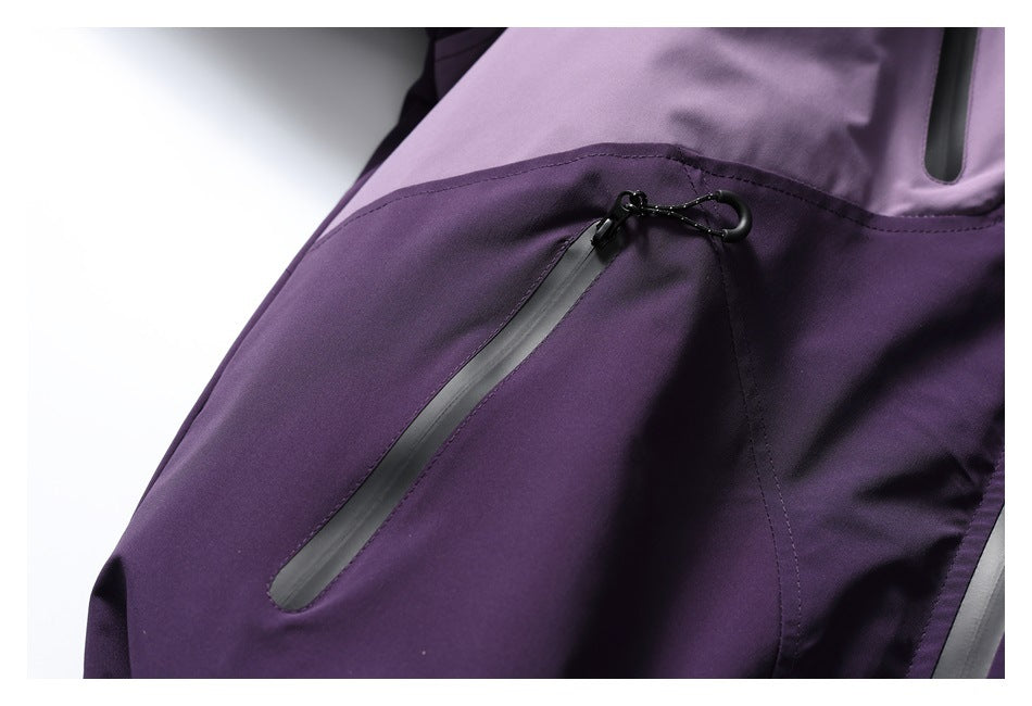 Close-up of a diagonal gray zip pocket and pull on the purple jacket.