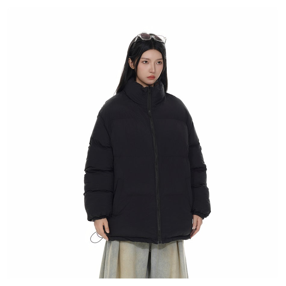 Front three-quarter view of a model wearing a black puffer jacket with a high collar.
