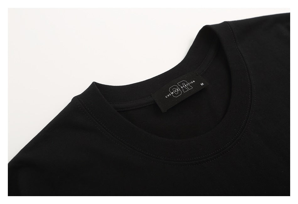 Close-up of the black T-shirt's crew neckline and sewn brand label.