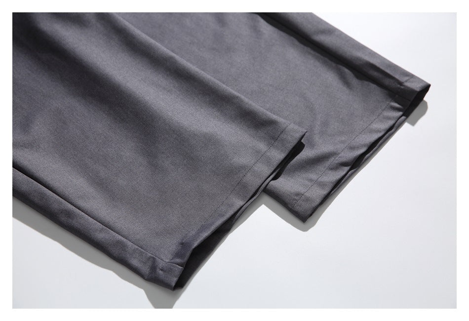 Close-up of charcoal trouser hems with straight stitched edges.