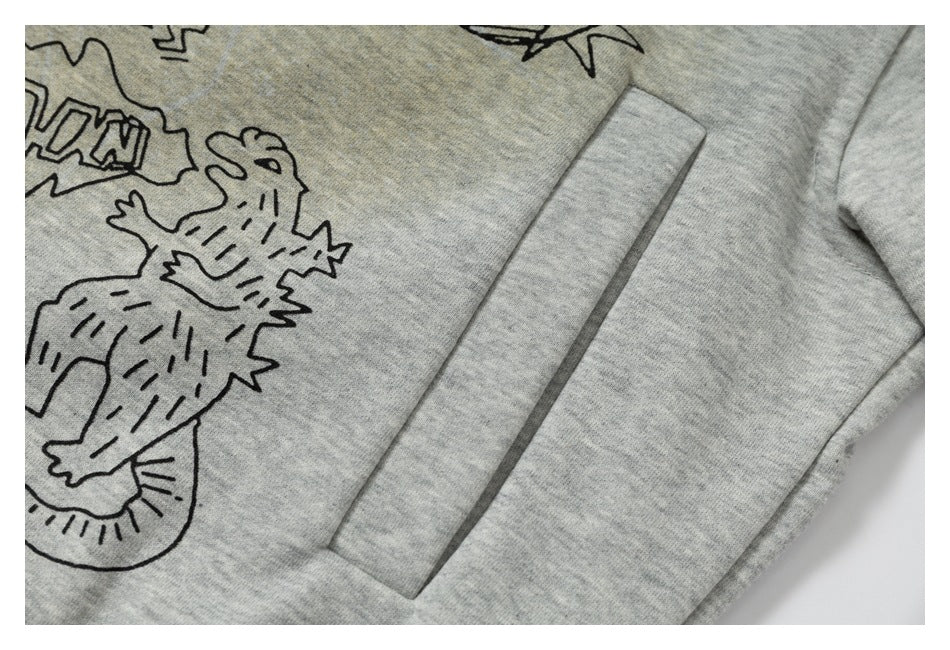 Close-up of a light gray hoodie pocket beside part of a black cartoon illustration.