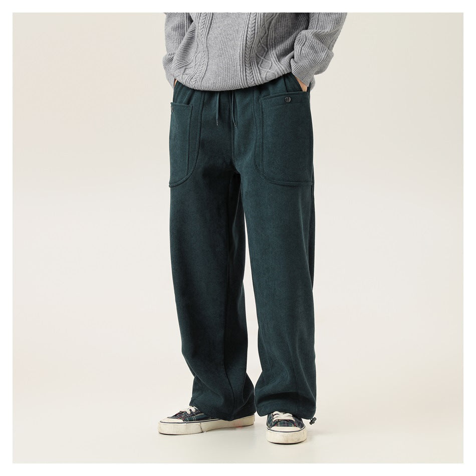 Model wearing dark teal wide-leg pants with large front patch pockets and a drawstring waist, shown from the front.