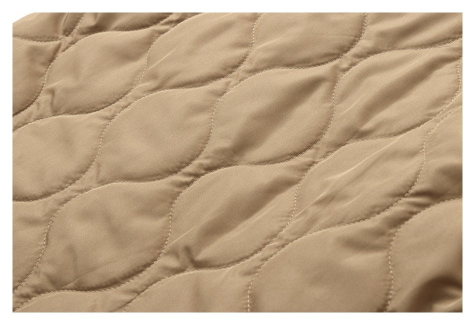 Close-up of tan quilted fabric with curved stitched channels.