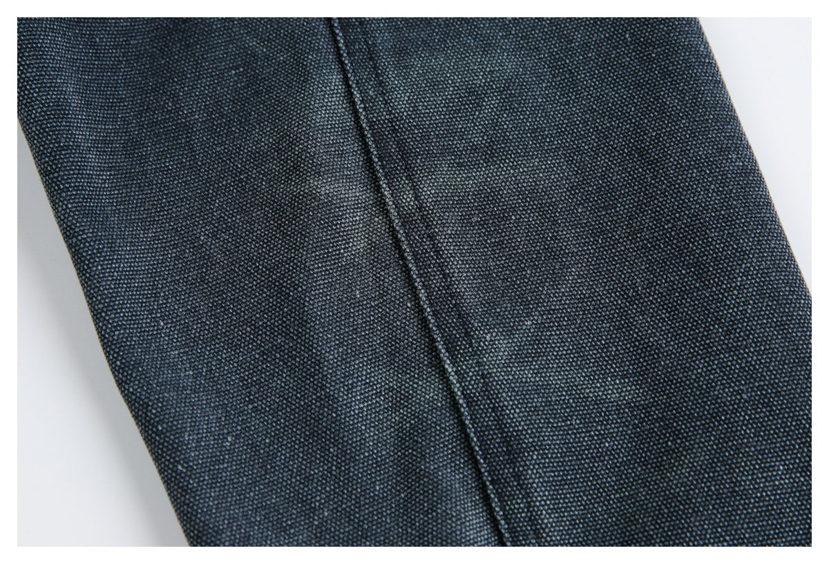 Close-up of dark charcoal-blue textured fabric with a straight stitched seam.