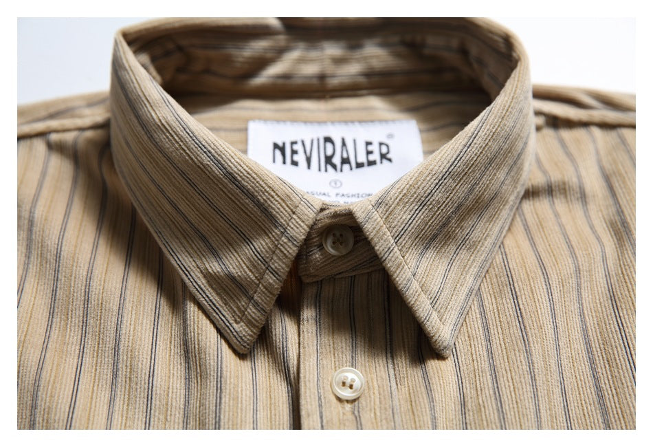 Close-up of a pointed collar and buttons on a beige shirt with fine dark vertical stripes.
