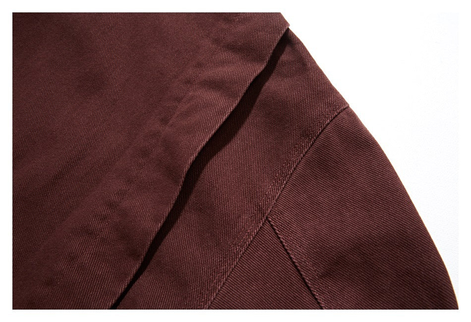 Close-up of a burgundy jacket shoulder seam and overlapping front panel.