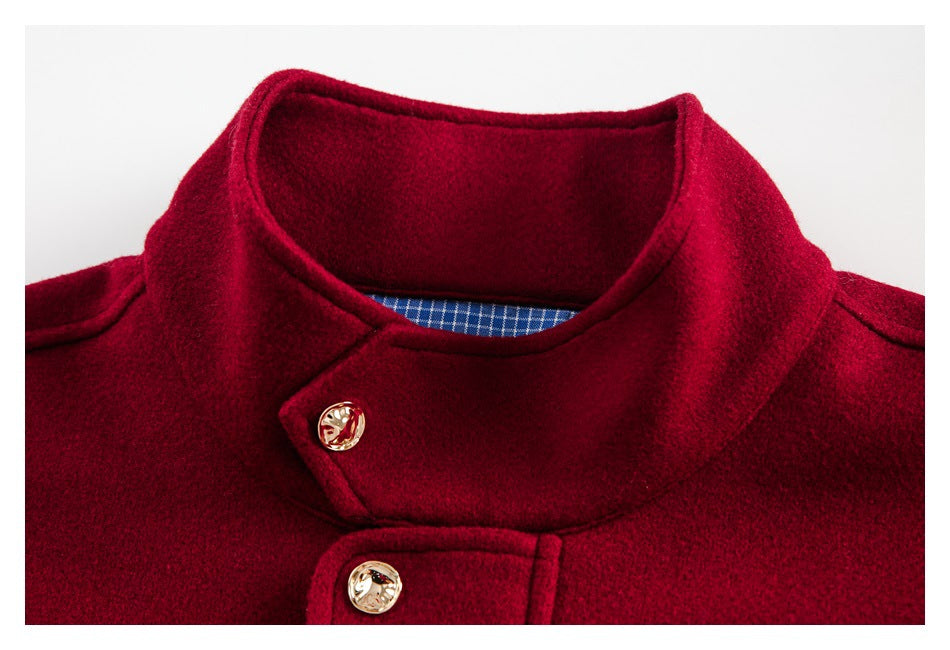 Close-up of a burgundy coat's rounded collar, gold-tone buttons and blue checked inner facing.