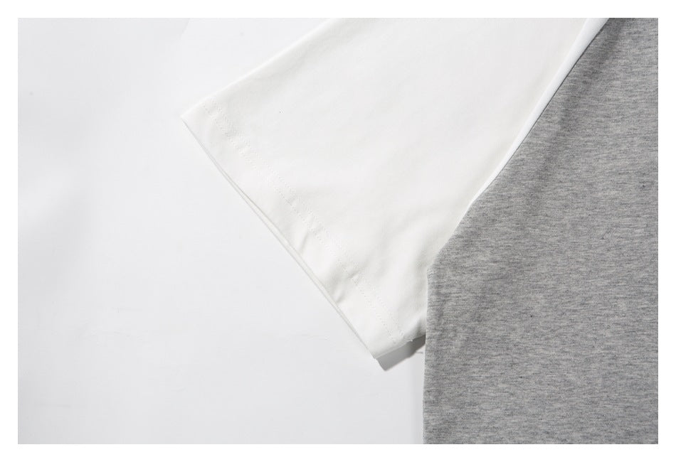 Close-up of a white sleeve and its stitched cuff beside the gray sweatshirt body.